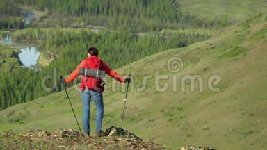 那个带着红色背包的旅行者的女人站在山上，看着雪山。
